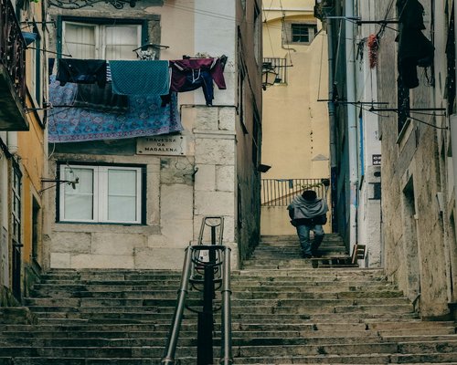 A person walking up some concrete stairs in an urban setting
